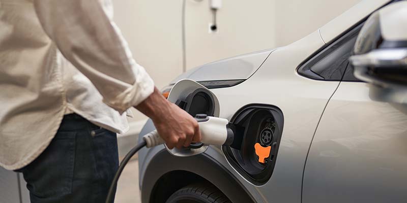 Man walking in the garage to charge a Chevrolet Bolt